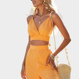 Noelijas minimālistisks tērps ar lencītēm rotātu kleitu un plūstošām detaļām